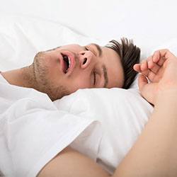 Man on his back snoring due to sleep apnea