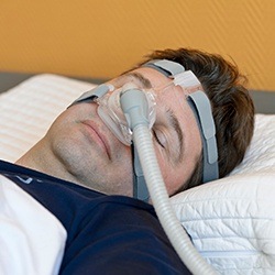 Man sleeping with CPAP nasal mask