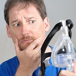 Man looking at CPAP mask