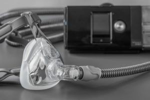 CPAP machine and mask on a gray table