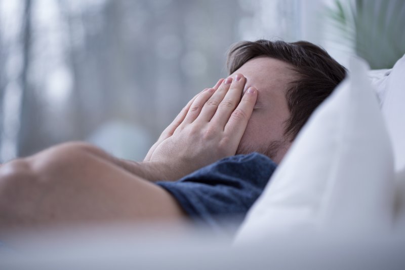 Man with sleep apnea lying awake in bed