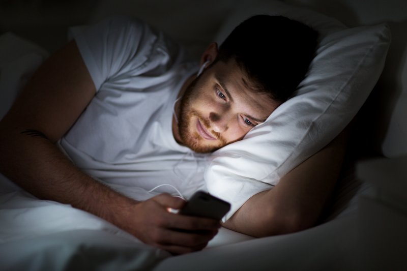 man on his cell phone in bed
