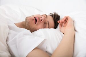 Close-up of man snoring in bed 